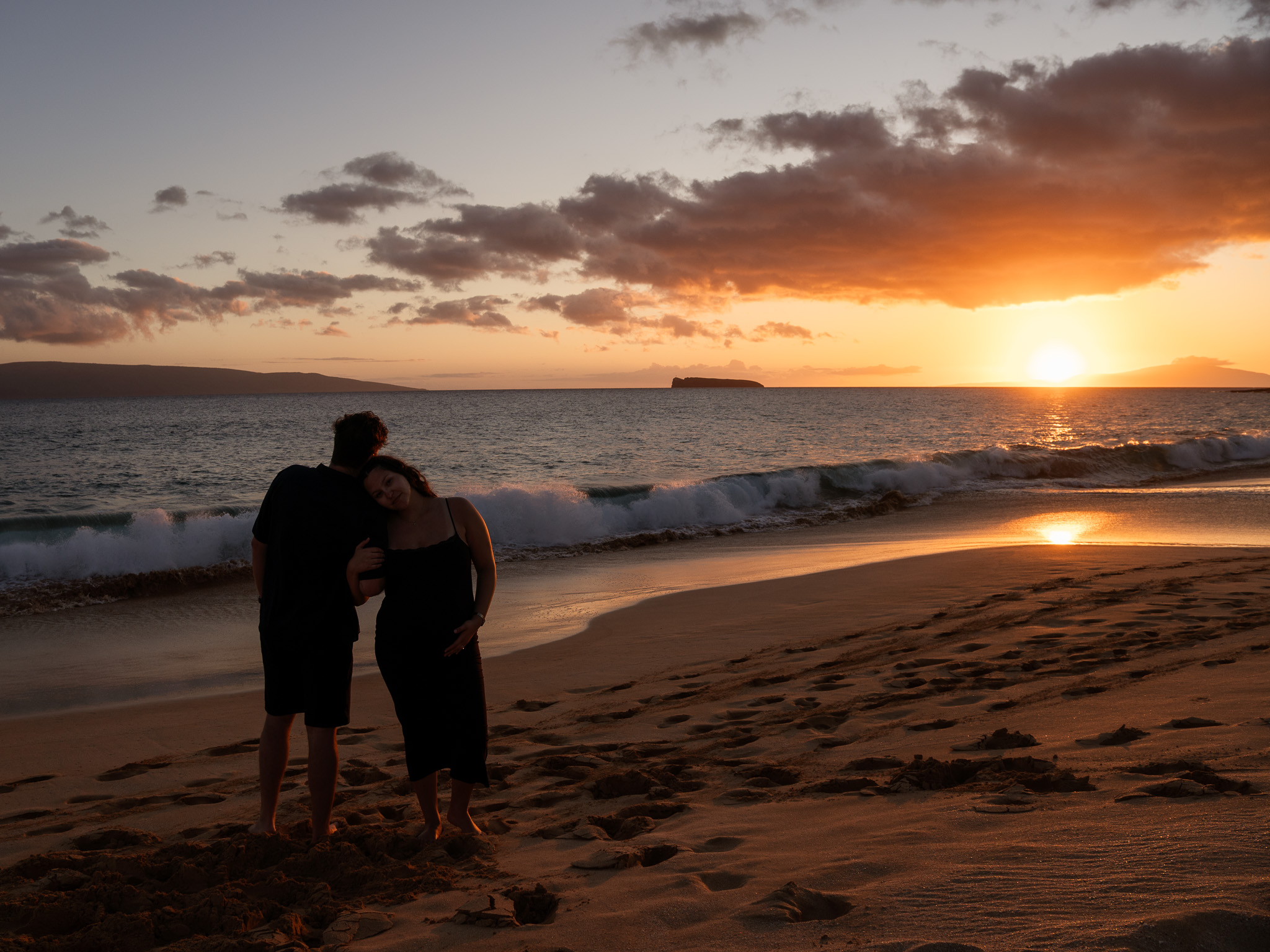 Expecting couple during a maternity session on the beach at sunset