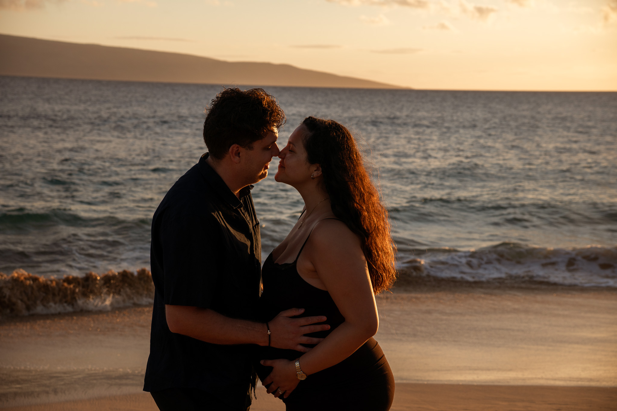 Maternity photo session of a couple on the beach at sunset