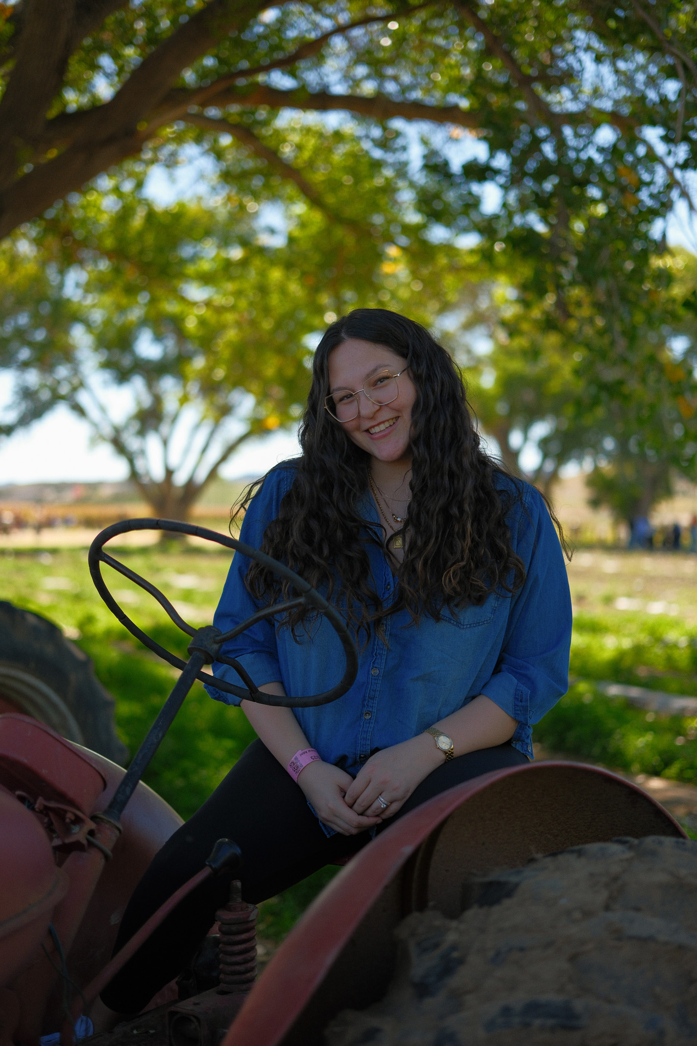 Portrait of a woman sitting on a tractor at a pumpkin patch during a fall photo session