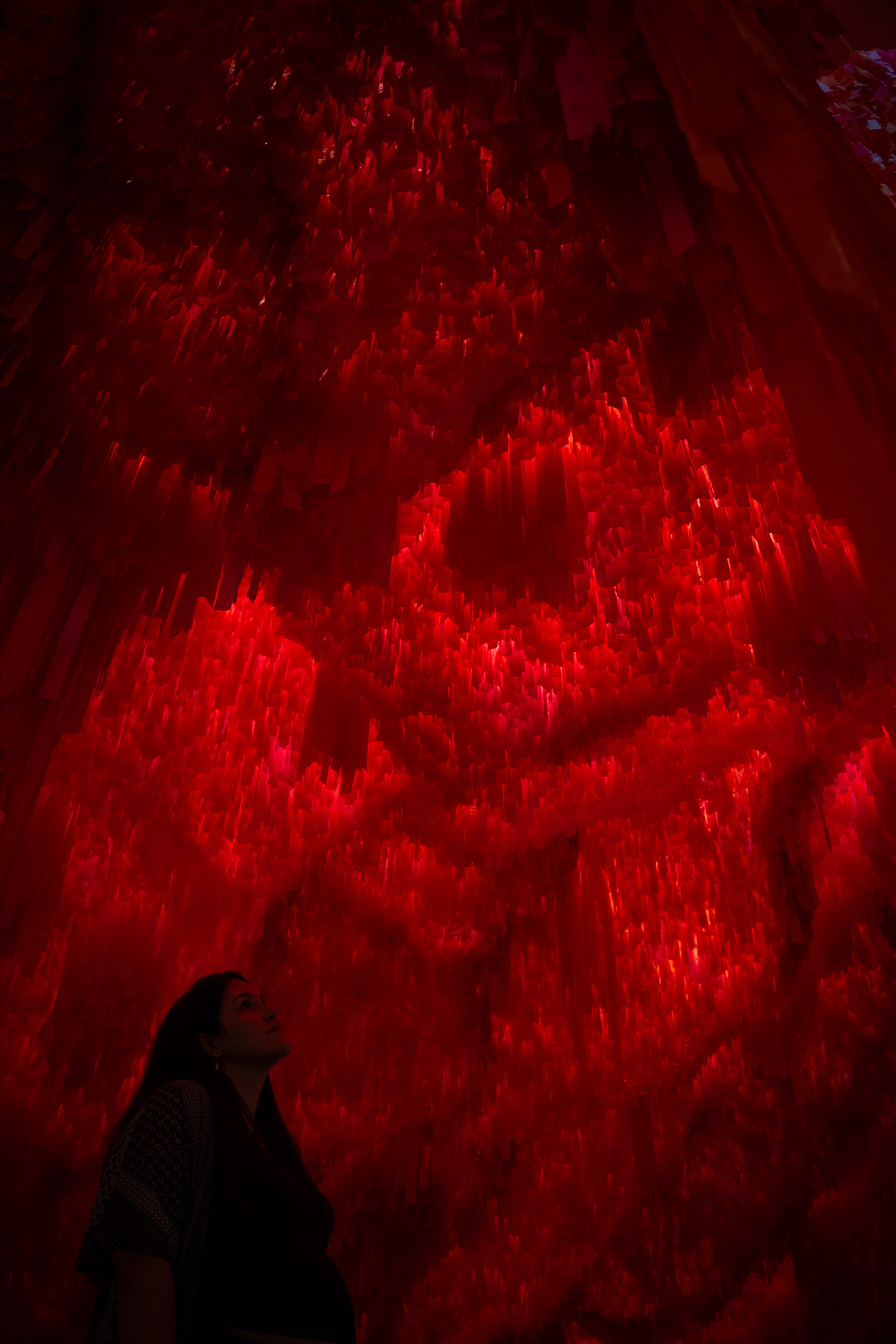 Creative red-lit portrait of a woman photographed at a Wonderspaces art exhibit